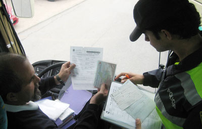 Un policía local de Las Rozas comprueba la documentación de un autobús escolar